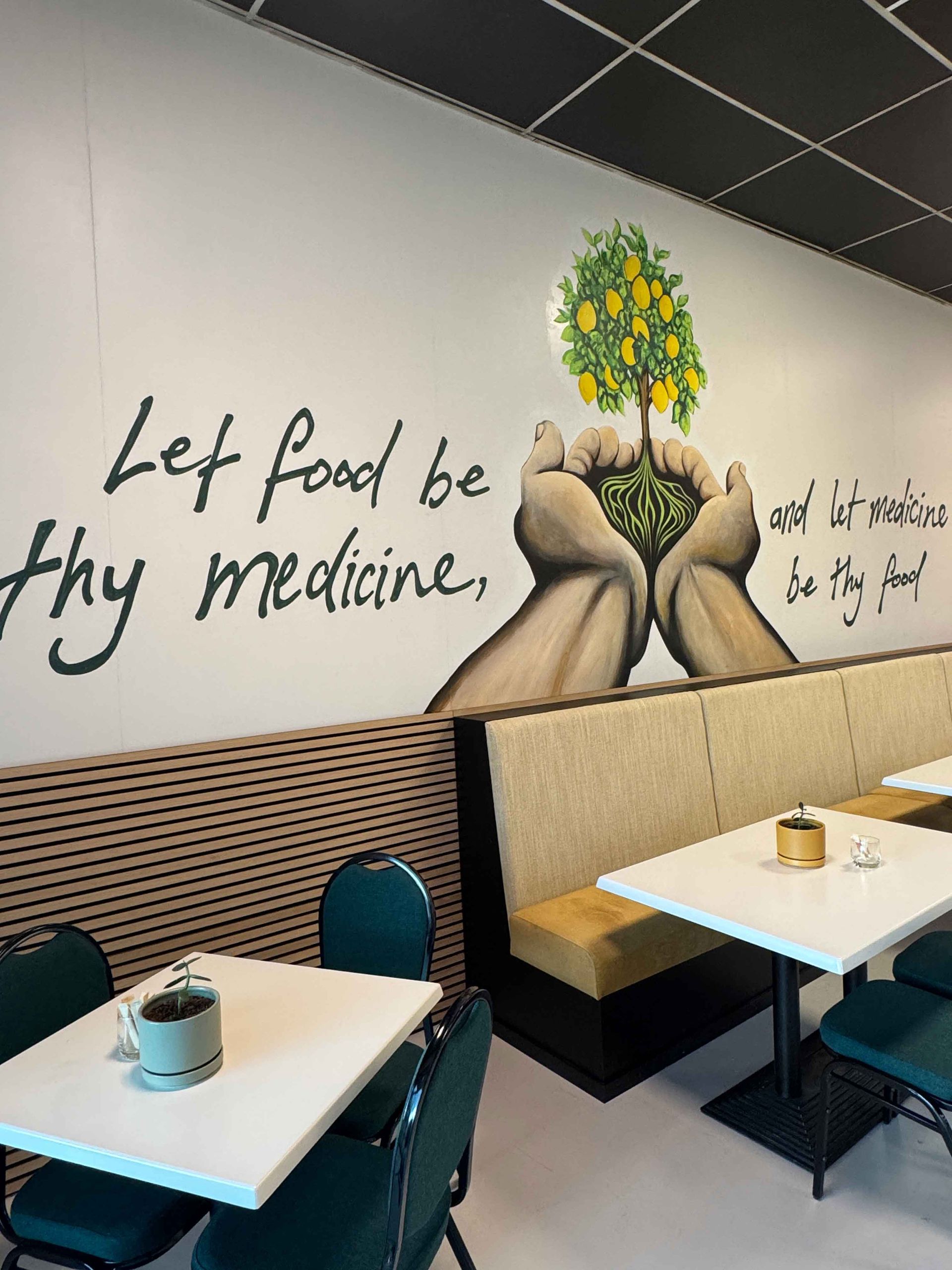 Cafe interior with a quote and mural on the wall: 