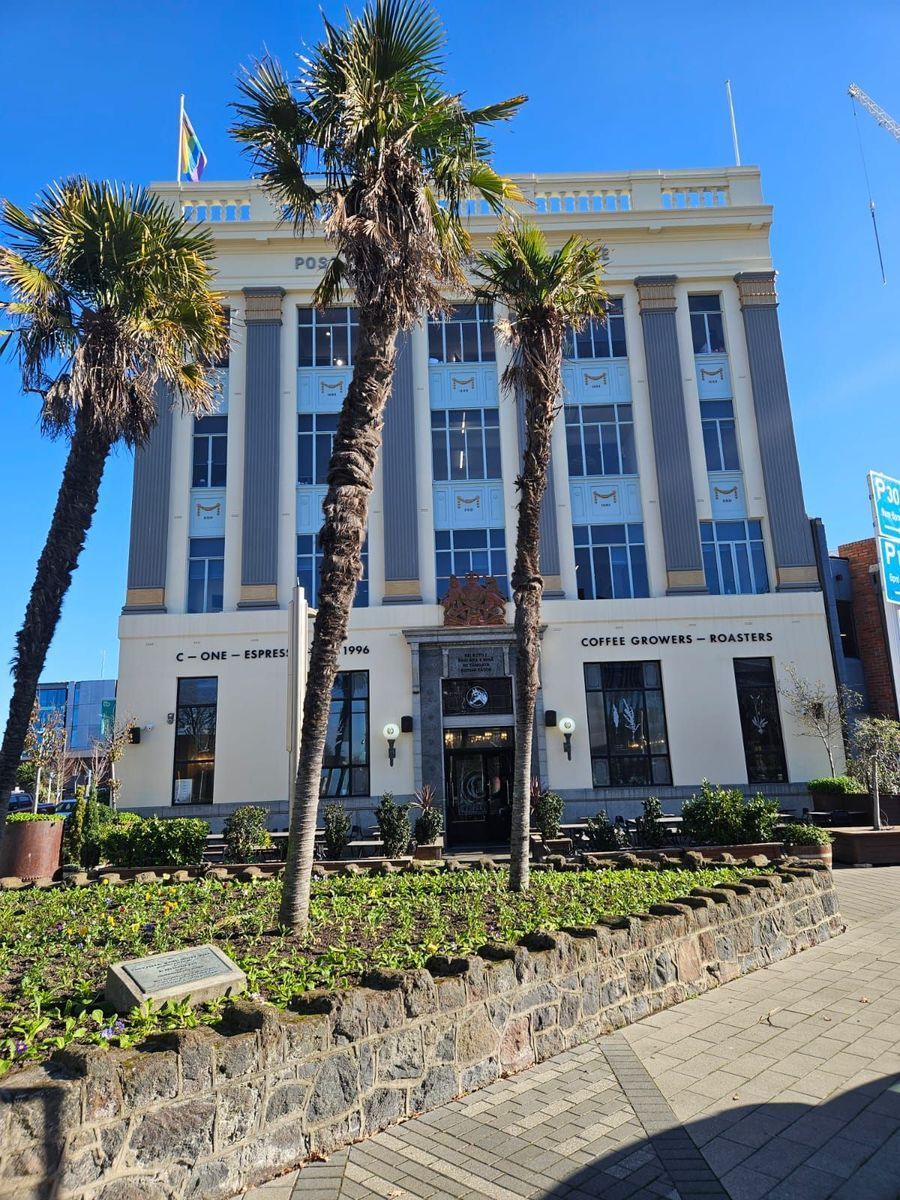 Building with light blue accents and palm trees.