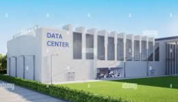 Modern data center building with a grassy lawn under a bright blue sky.