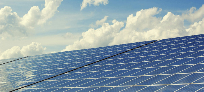 Solar panels under a partly cloudy sky.