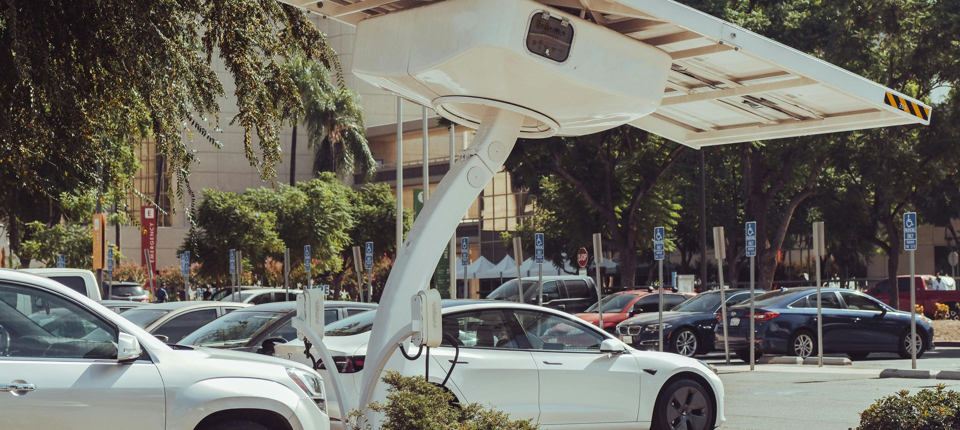 Man on a roof installing a solar panel. He is wearing a black shirt, and a window is visible behind him.