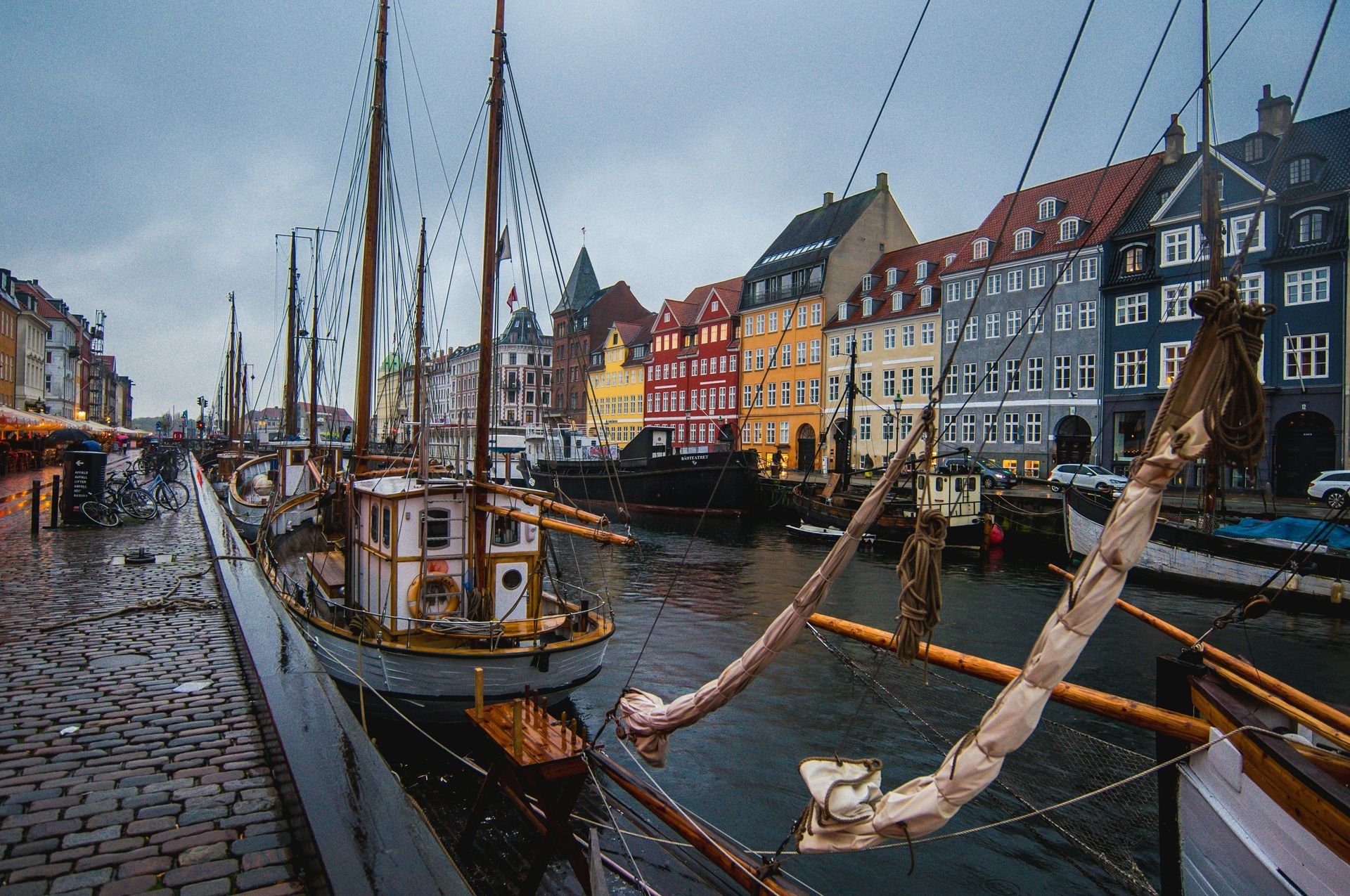 A boat is docked in a harbor with buildings in the background in Copenhagen