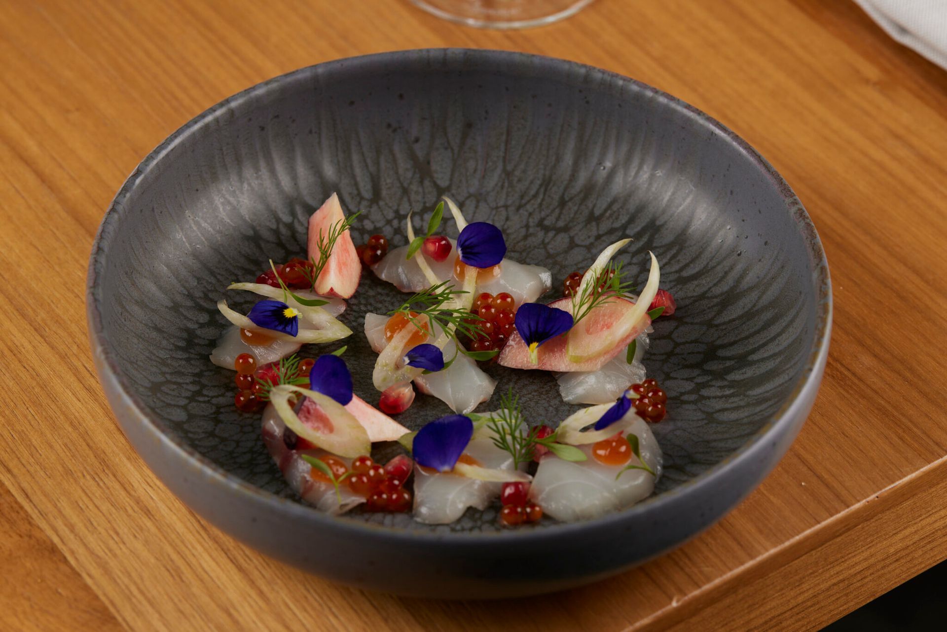 A bowl of food is sitting on a wooden table.