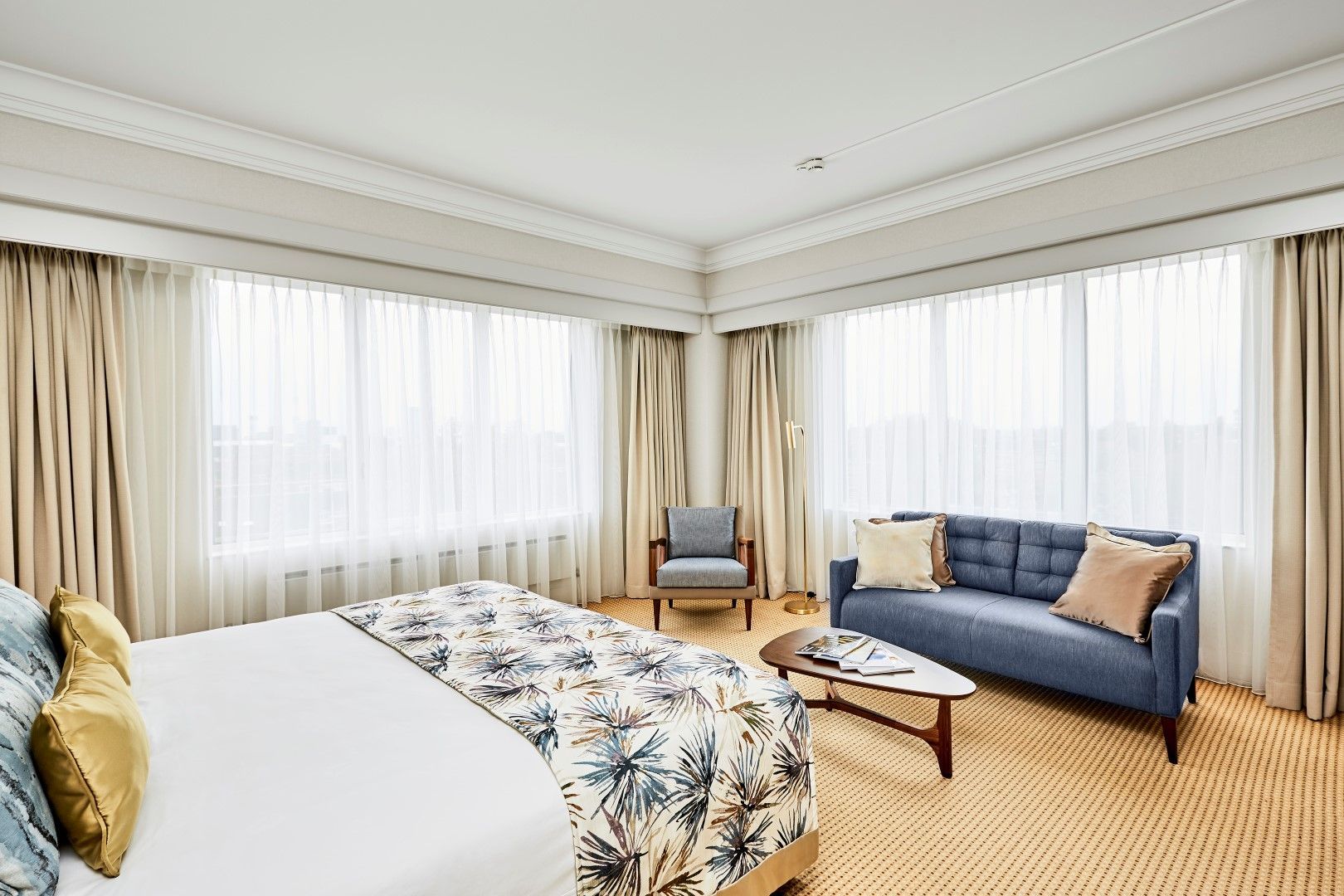 A hotel room with a bed , couch , chair and table.