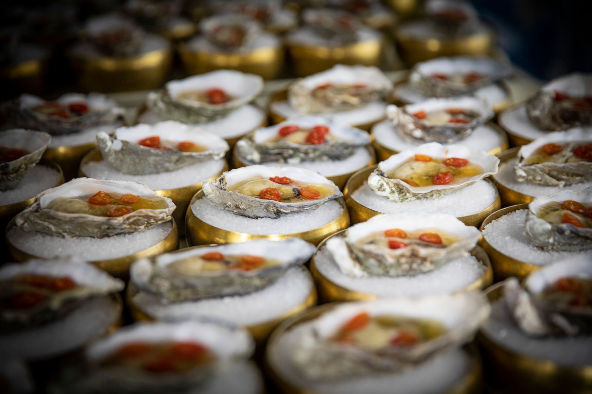 Een stel oesters die op een tafel bovenop elkaar liggen