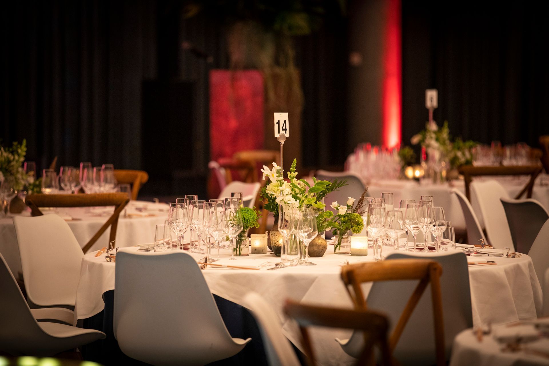 A room filled with tables and chairs set up for a wedding reception.