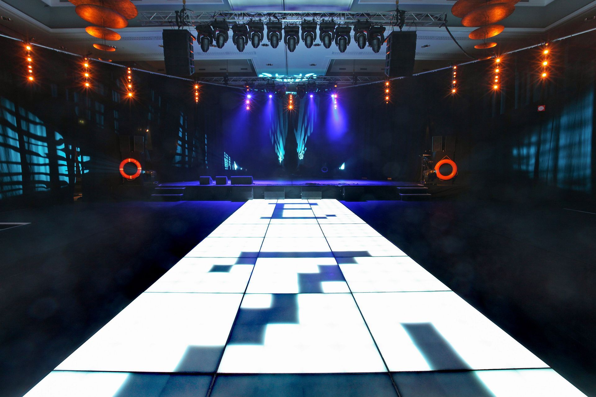An empty stage with a dance floor in the middle of it