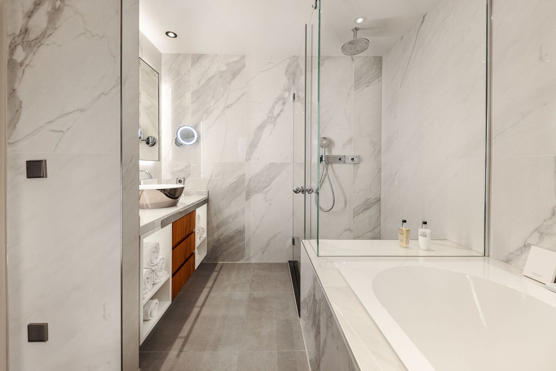 A bathroom with a tub , sink , shower and mirror.