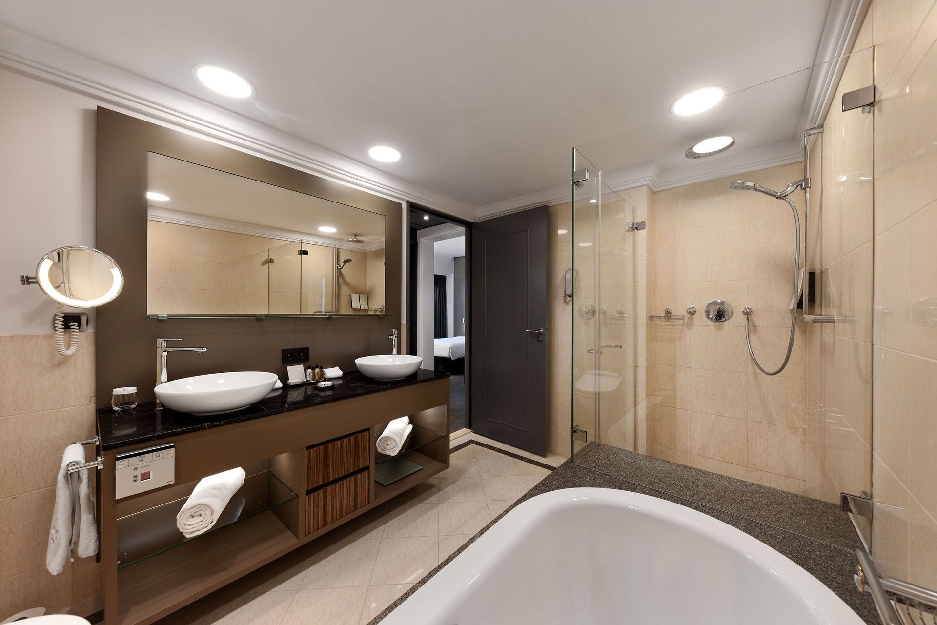 A bathroom with a bathtub , sinks , mirrors and a walk in shower.