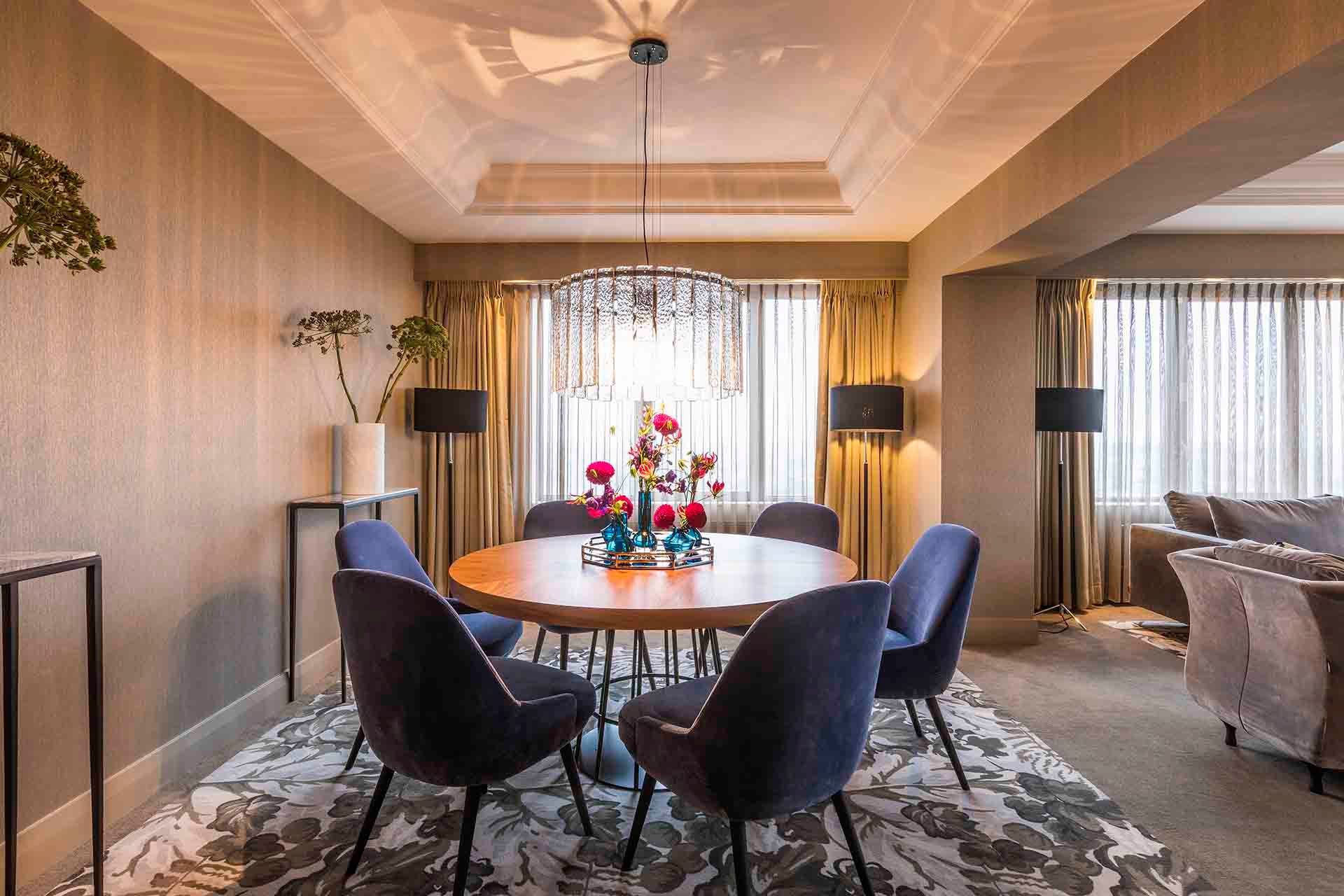 A dining room with a table and chairs and a chandelier.