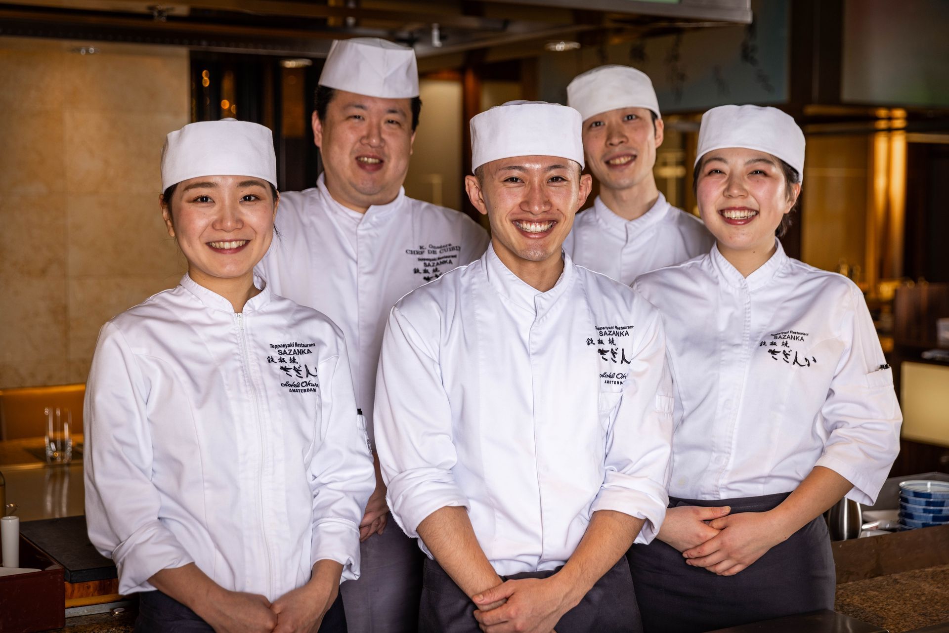 A group of chefs are posing for a picture in a restaurant.