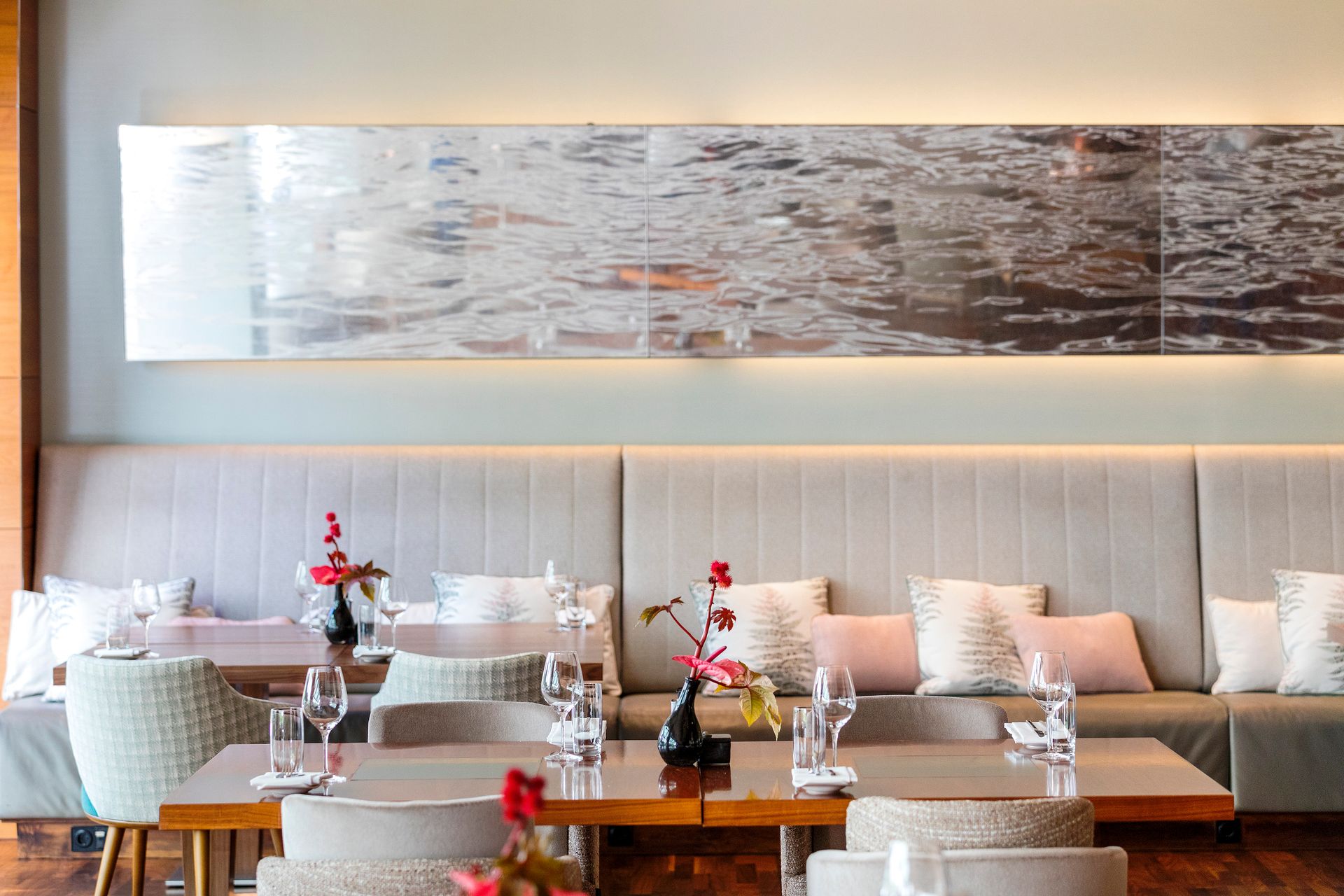 Een restaurant met tafels en stoelen en een schilderij aan de muur.