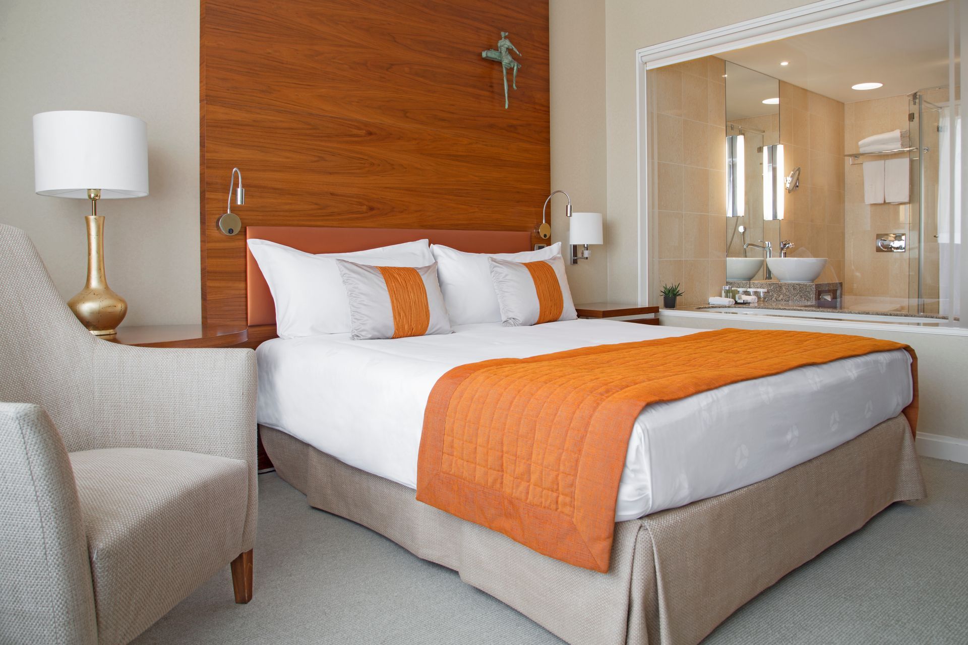 A hotel room with a large bed and a chair