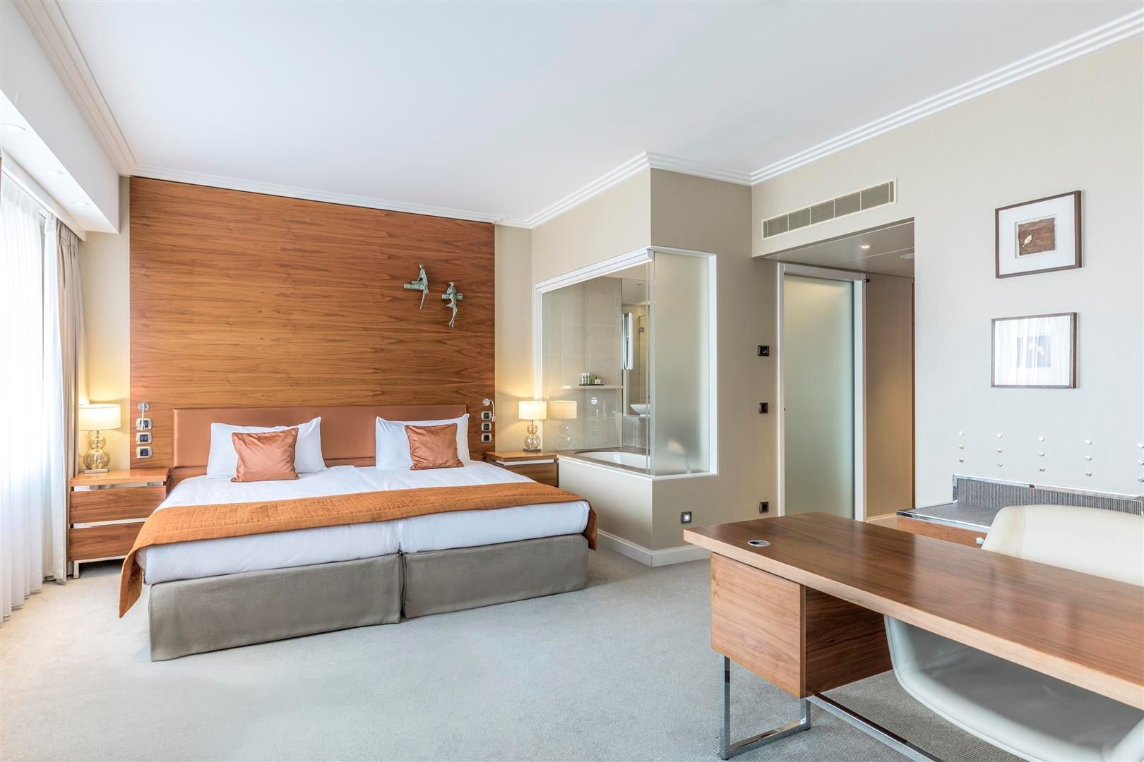 A hotel room with a large bed and a desk.