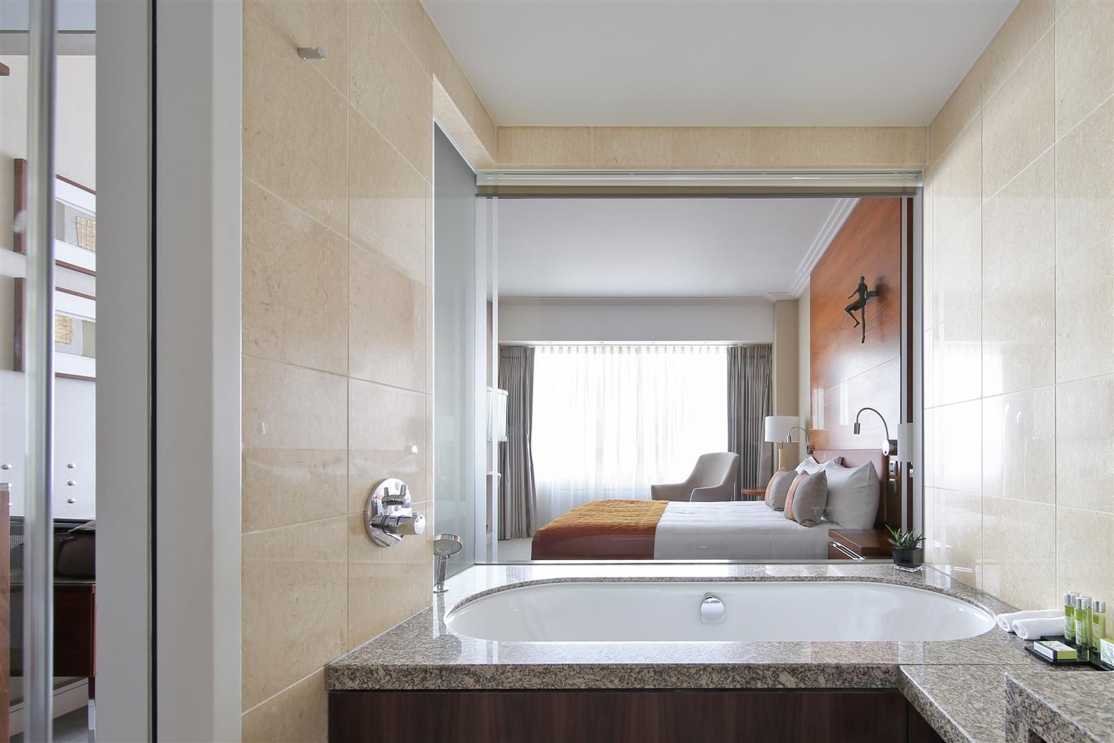 A hotel room with a bathtub and a bed