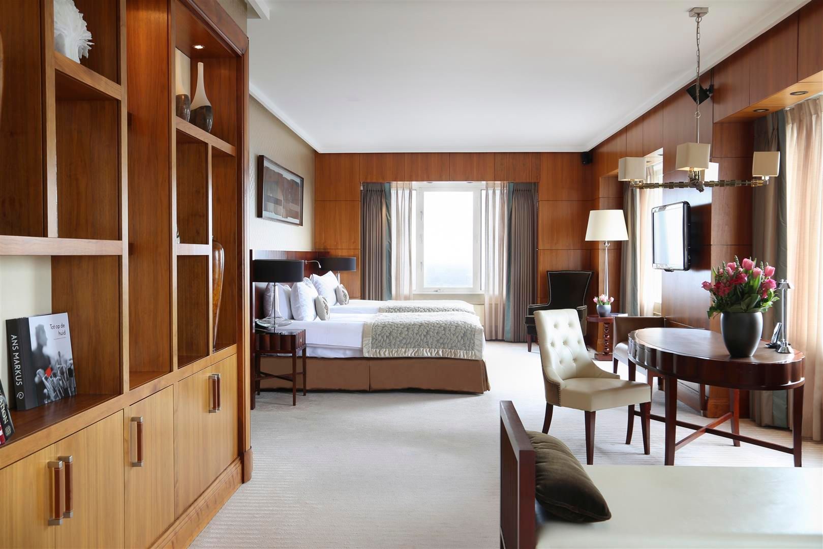 A hotel room with two beds and a table