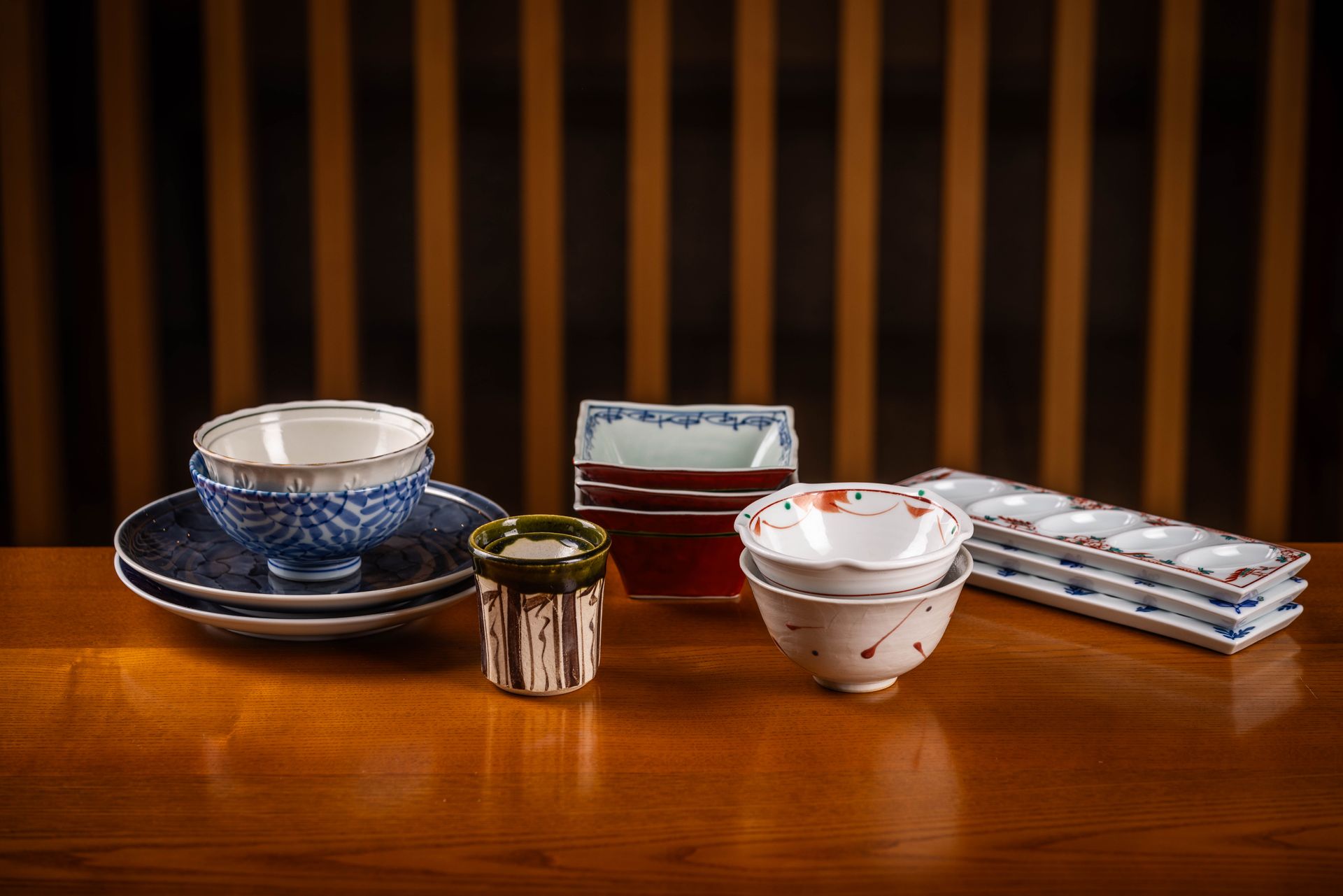 There are many different types of bowls and plates on the table.
