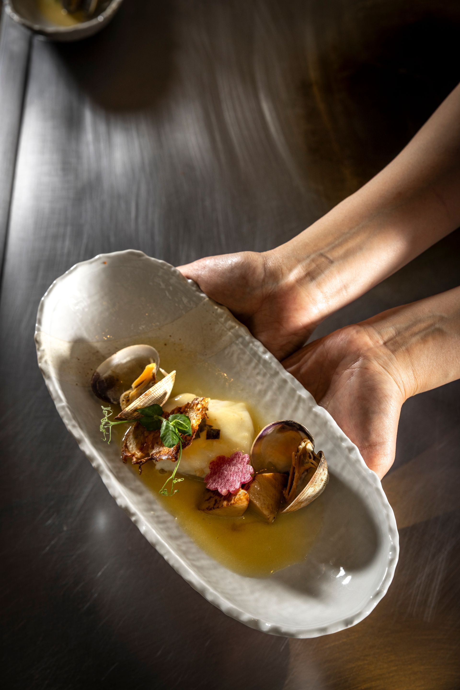 A woman is cooking food on a grill in a restaurant.