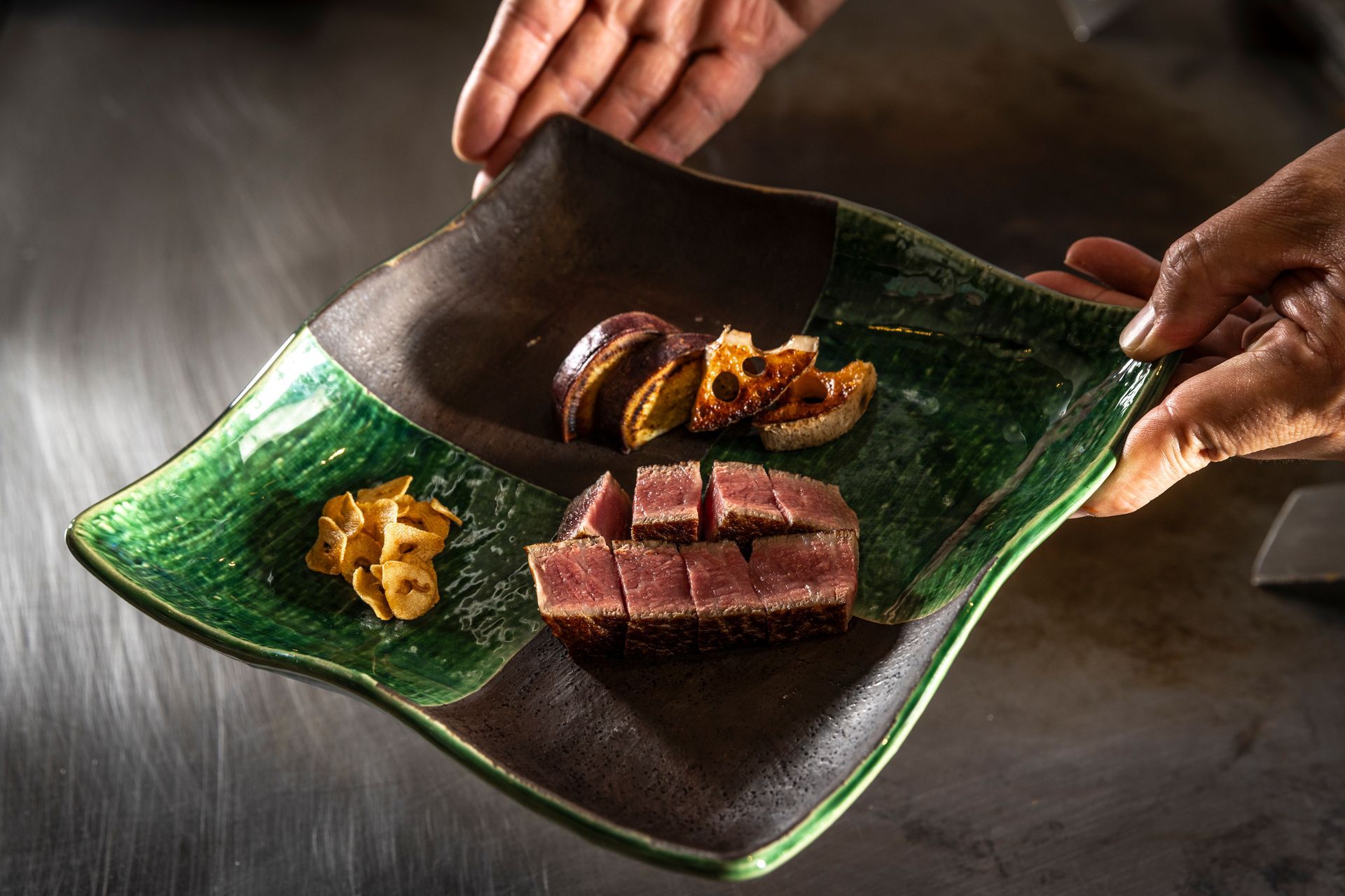 A chef is preparing food on a stove with a spoon.