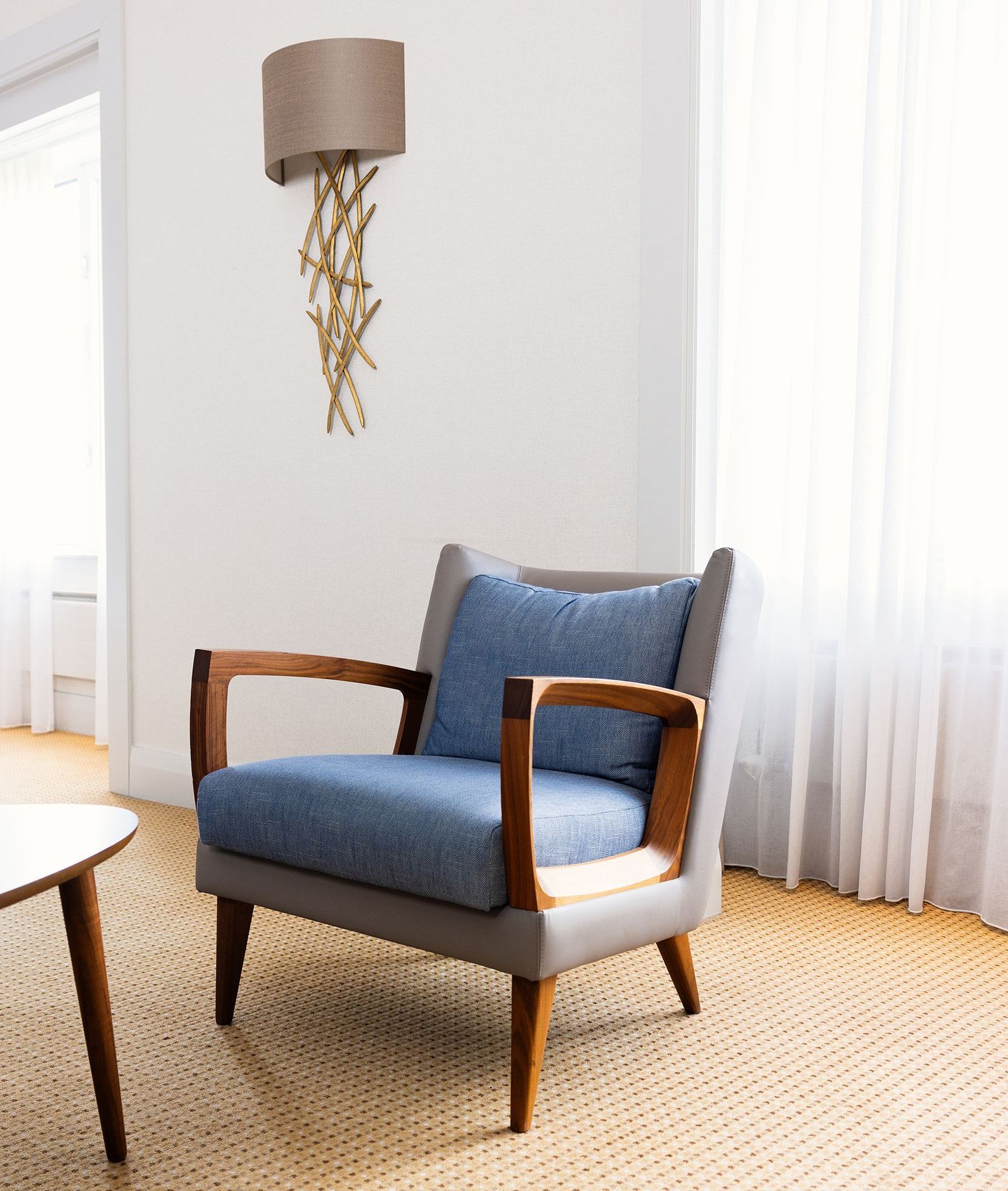 A living room with a chair and a lamp on the wall