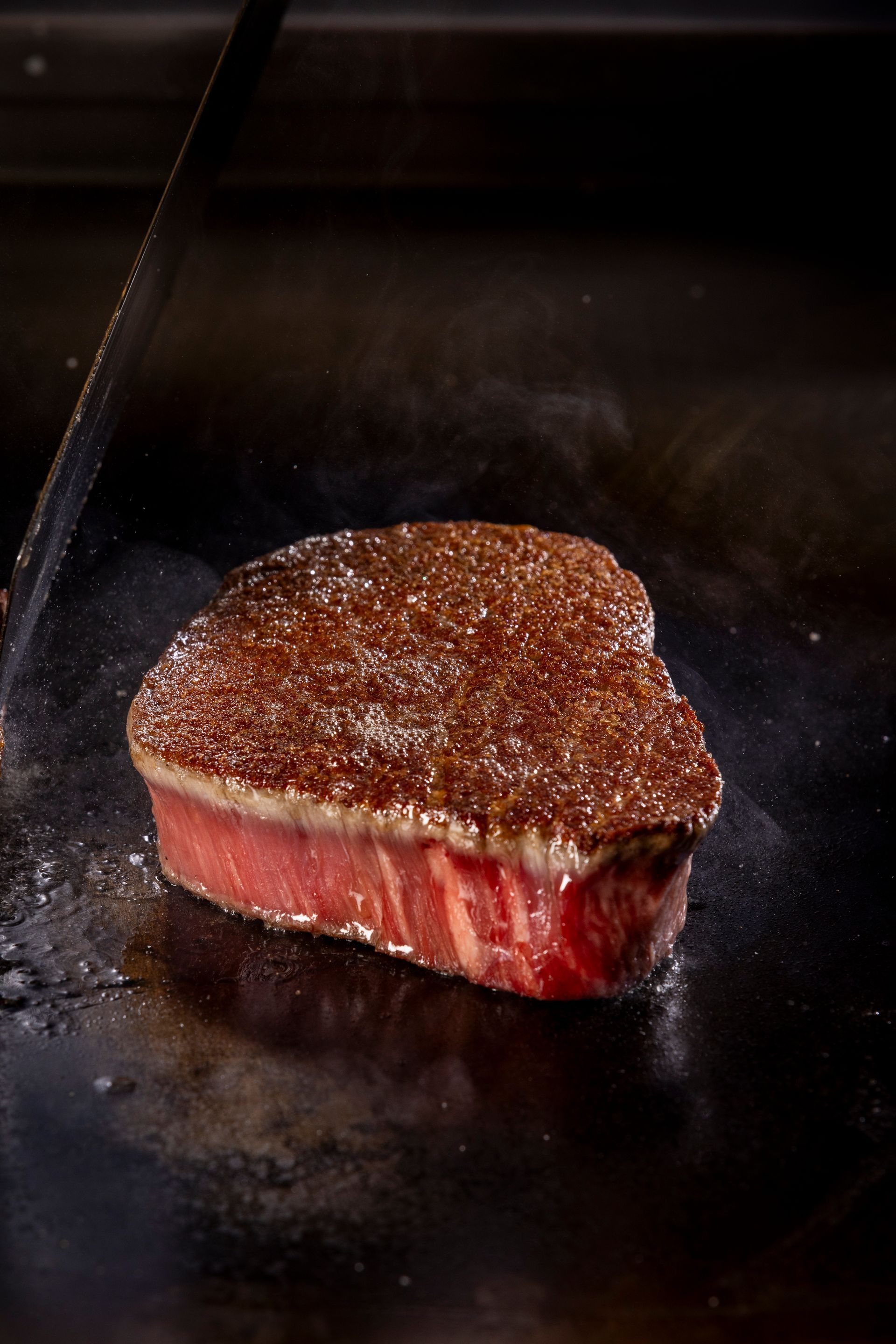 Een vrouw in een koksuniform bereidt eten in een restaurant.
