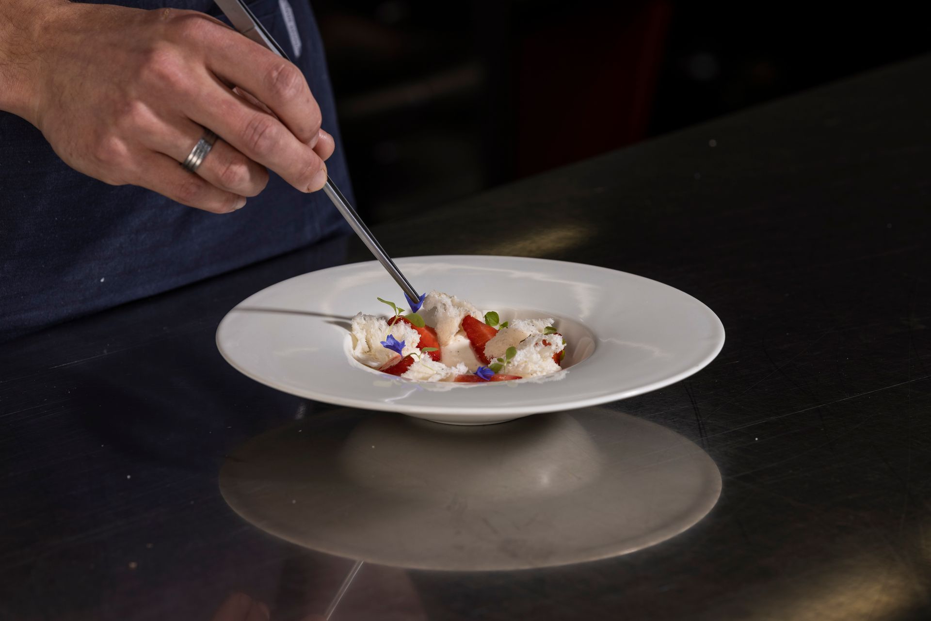 A bowl of food and a glass of wine on a table.