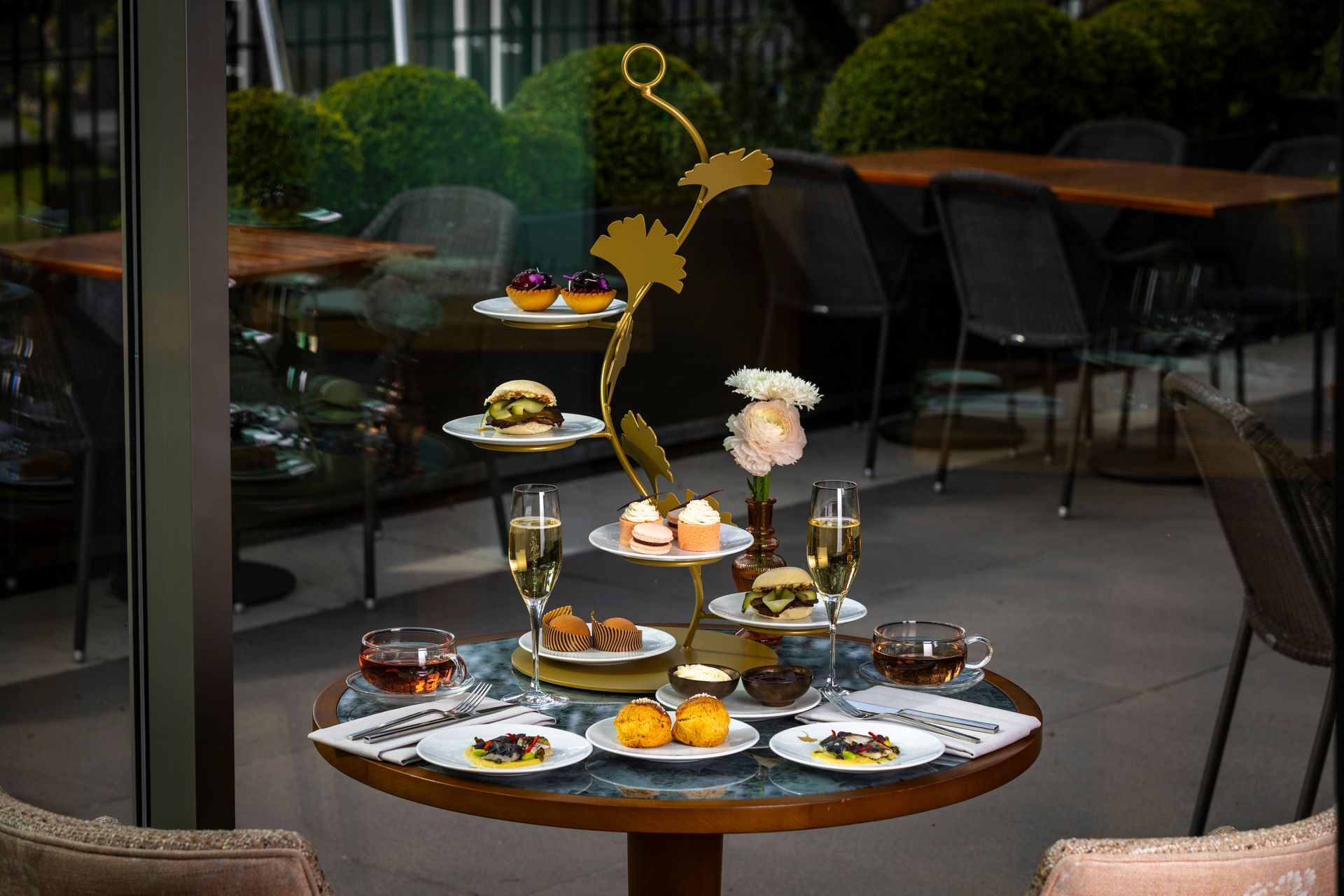 A table with plates of food and wine glasses on it.