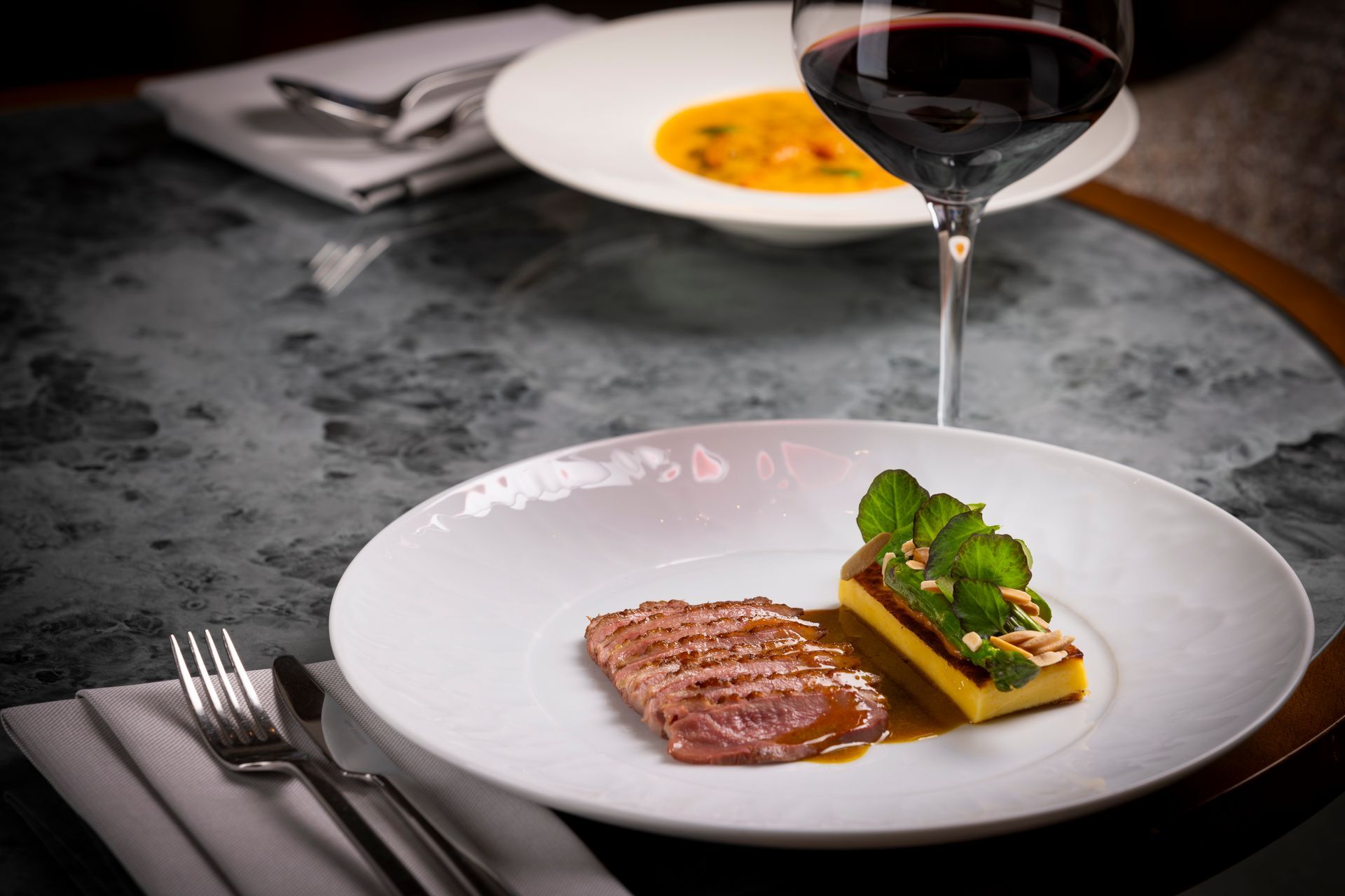 A plate of food and a glass of wine on a table.