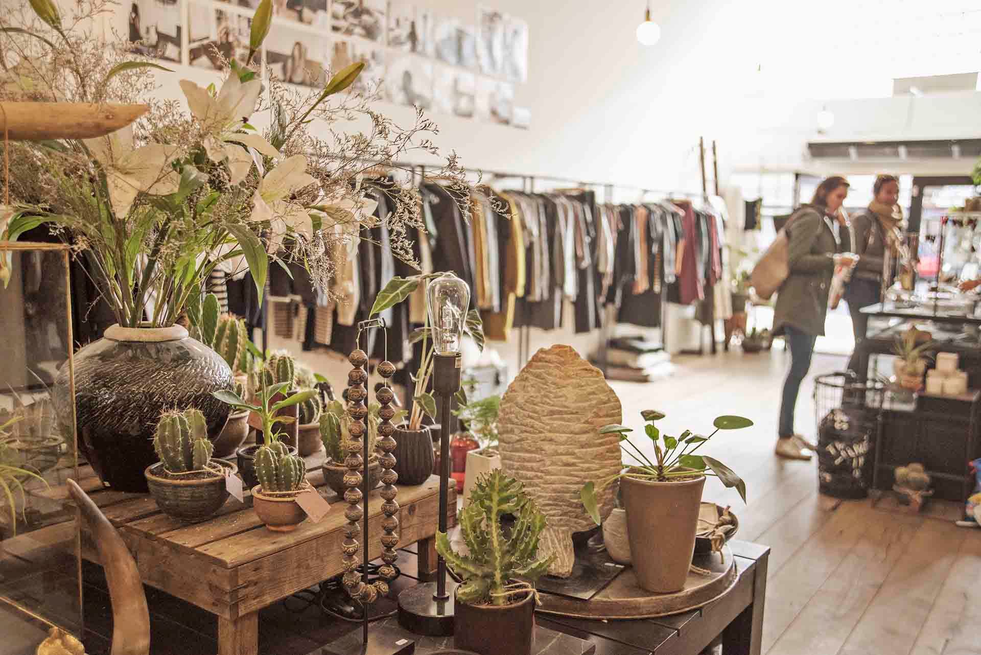 A woman is standing in a store looking at clothes.