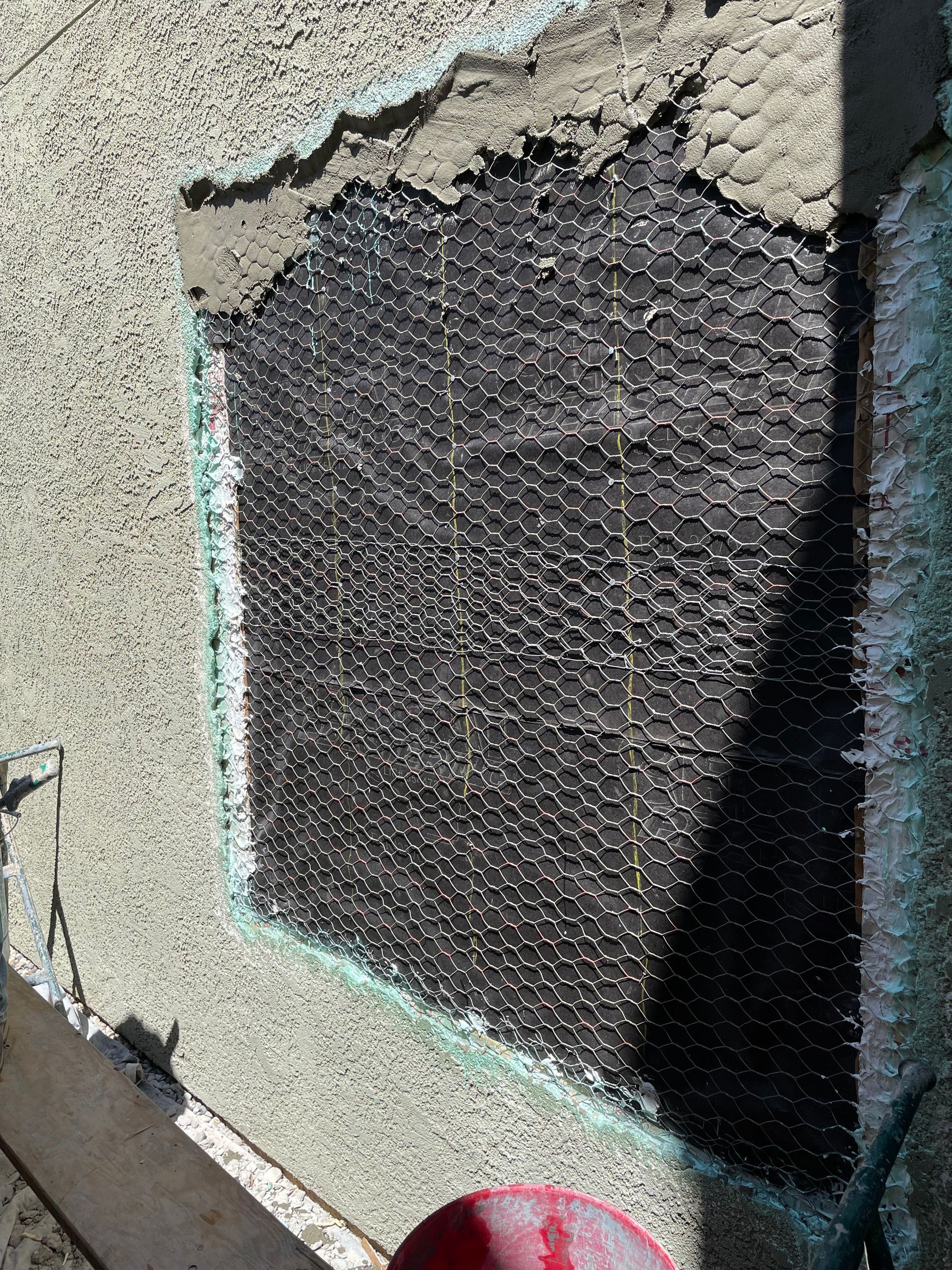 A man is installing insulation on the side of a building.