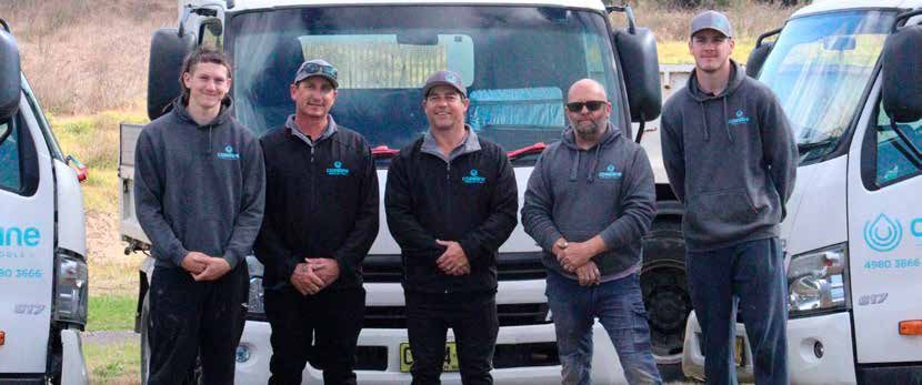 A group of men are standing in front of a truck.