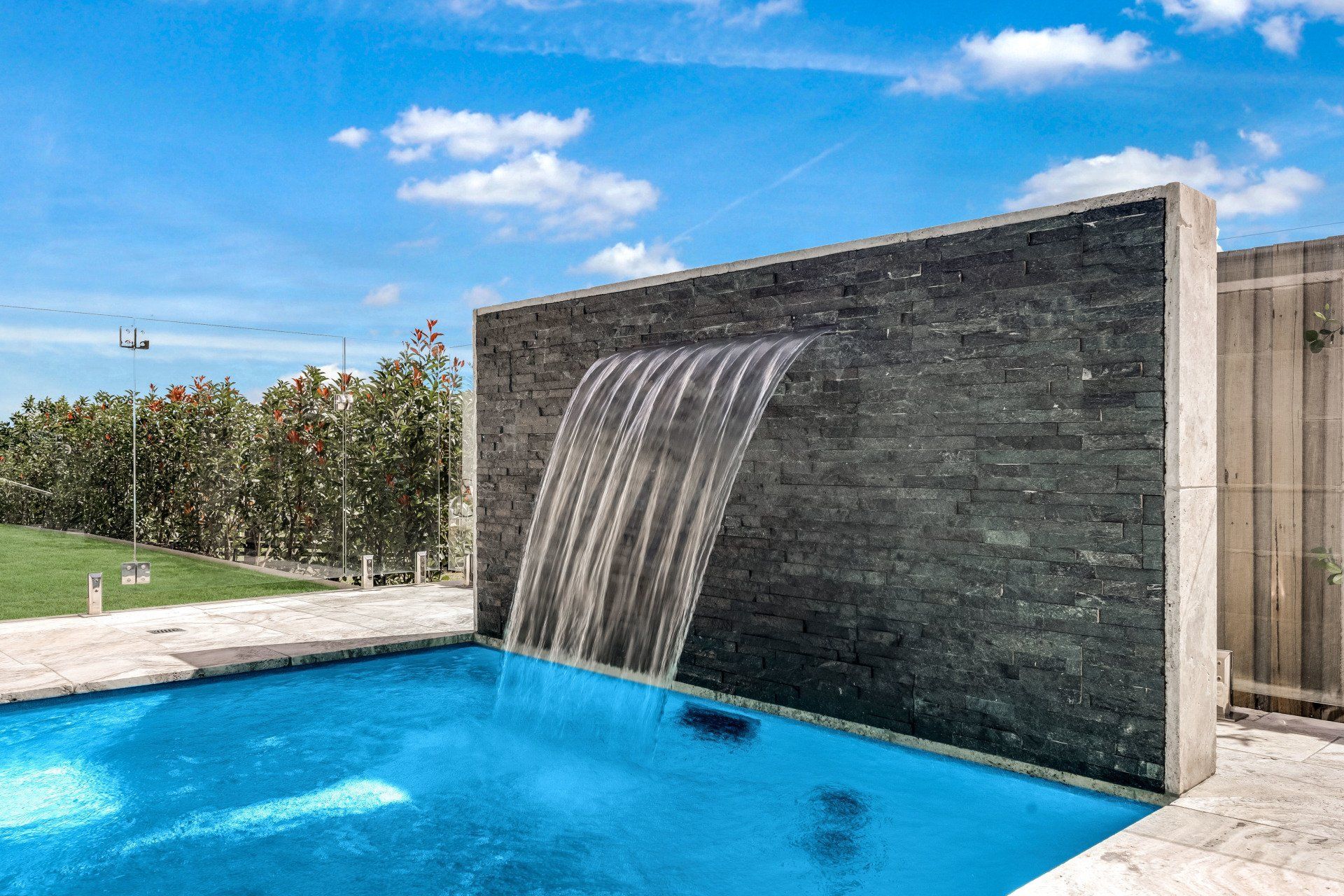 A swimming pool with a waterfall on the side of it.