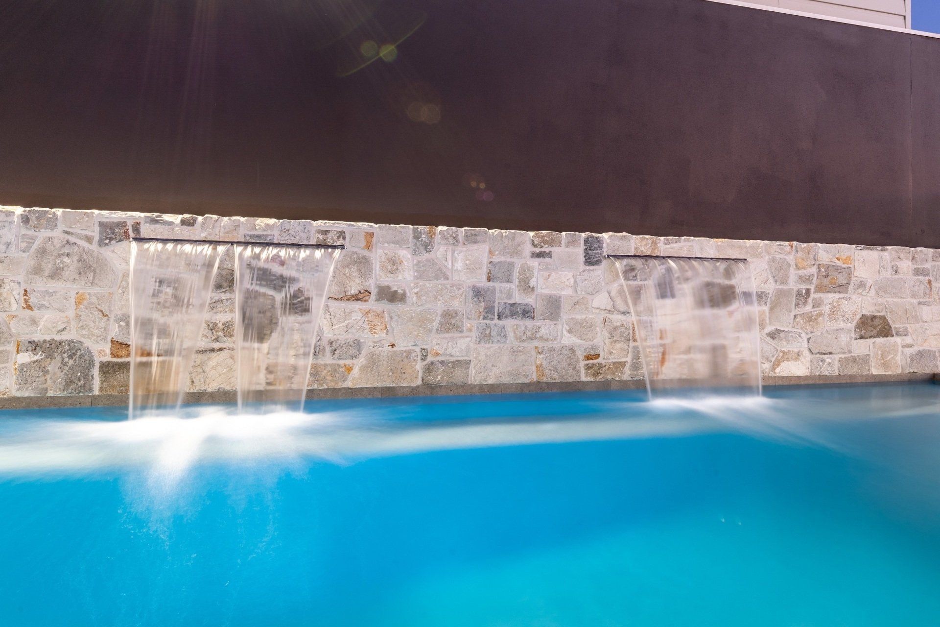 There is a waterfall in the middle of the pool.