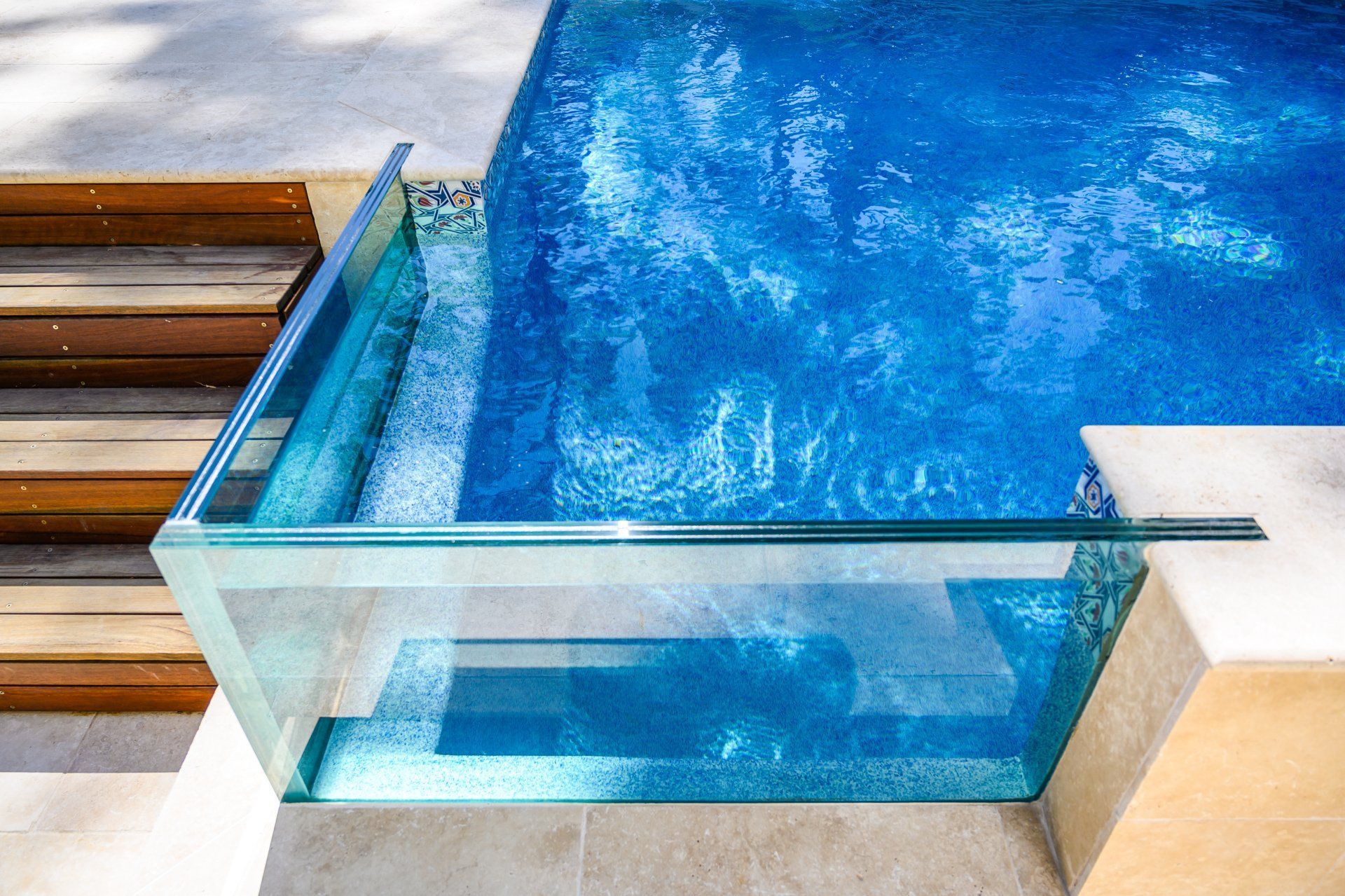 A large swimming pool with a glass fence around it