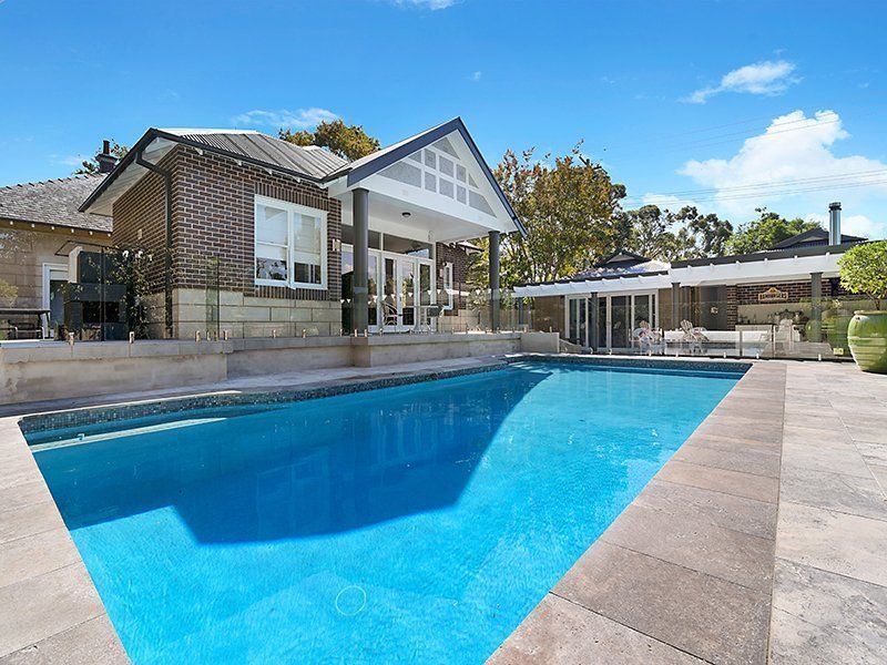 A large house with a large swimming pool in front of it.