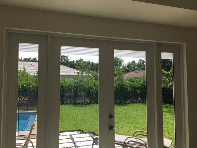 House With Glass Door And A Pool Outside — Miami, FL — Solar Tint, Inc.