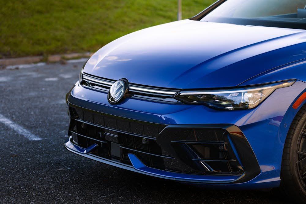 Close-up of blue sports car front with sleek headlights.