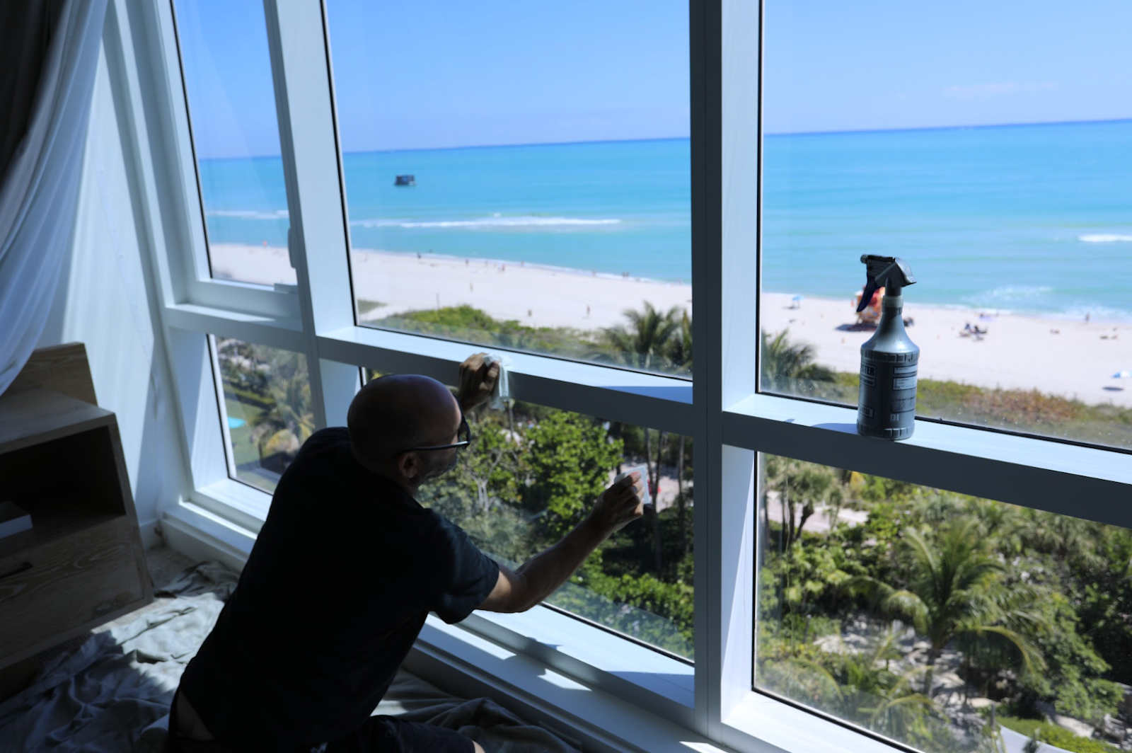 Worker fitting window film in a luxury hotel suite.