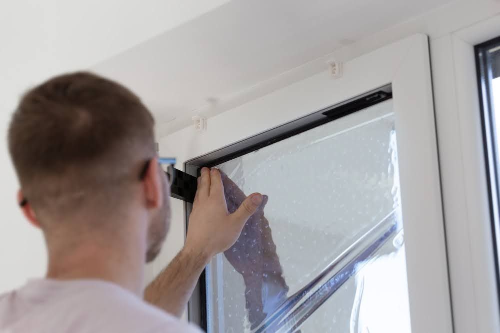 A professional installing a window film.