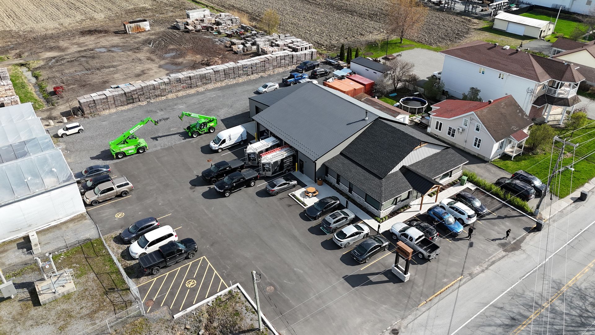 Une vue aérienne d'un parking avec des voitures garées devant un bâtiment.