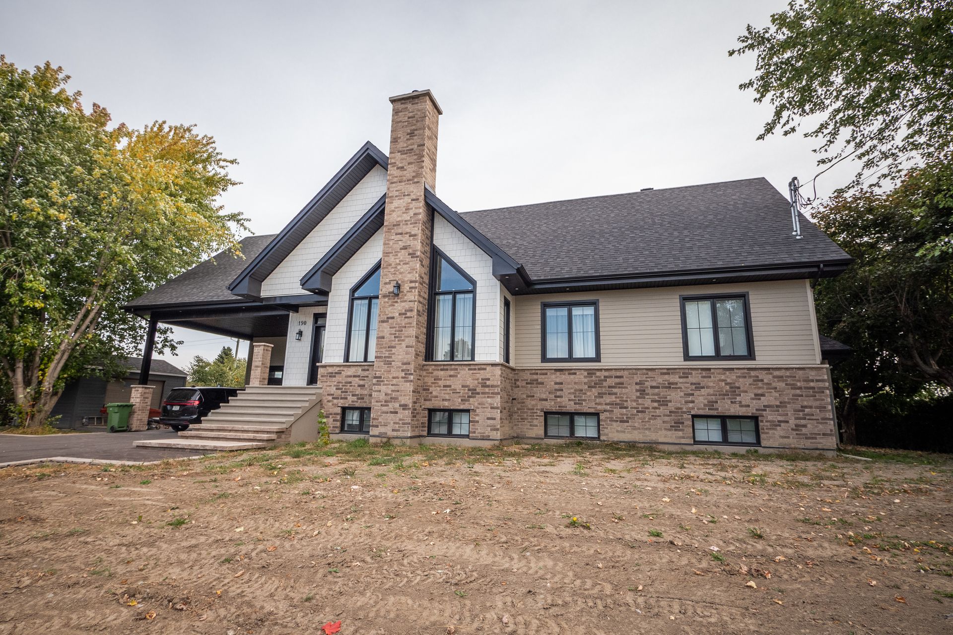 Une grande maison avec une cheminée et beaucoup de fenêtres