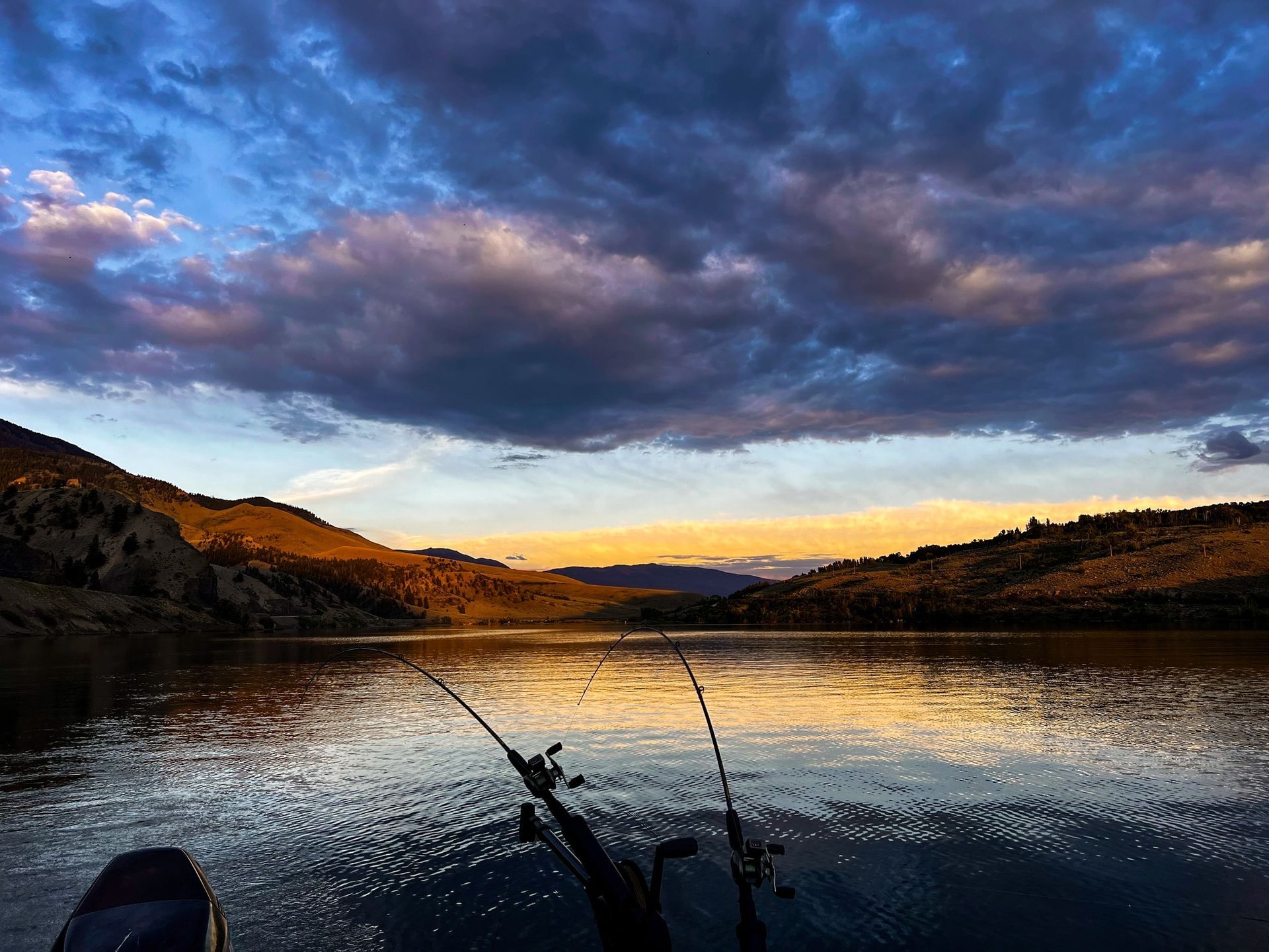 A person is fishing on a lake at sunset glenwood springs