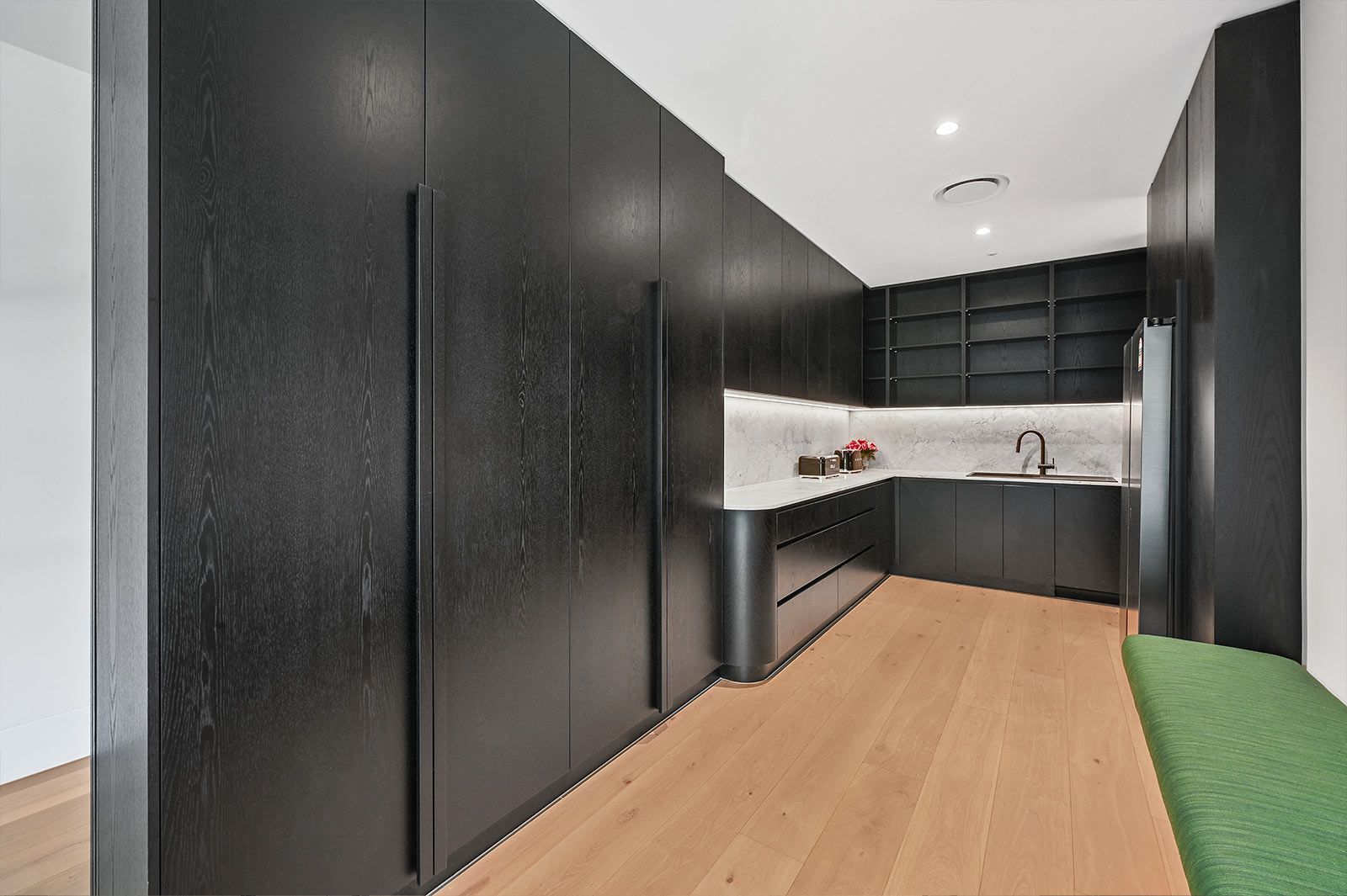 Black-paneled kitchen with wooden floors, white countertops, and open shelving — PK Kitchen Design in West Ipswich, QLD