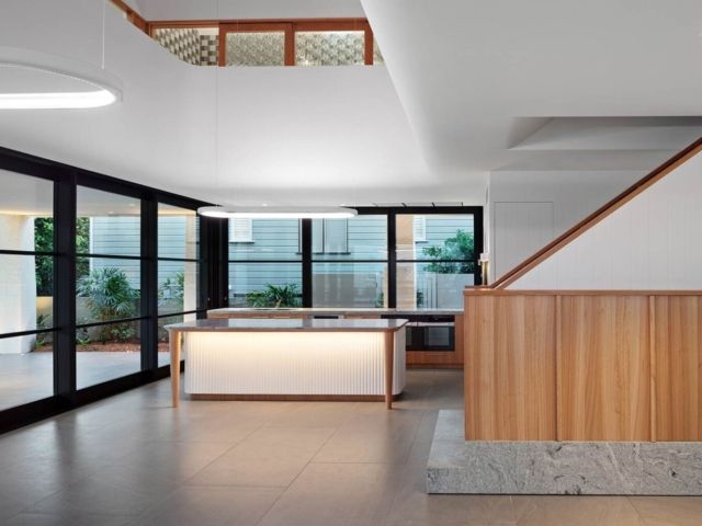 Modern interior with wood accents, large windows, and a central counter. Bright and airy space — PK Kitchen Design in West Ipswich, QLD