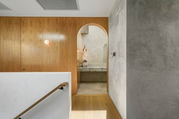Hallway with wooden walls, an arched doorway to a bathroom with a stone sink, and a staircase — PK Kitchen Design in West Ipswich, QLD
