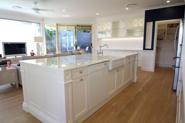 White kitchen island with marble countertop, hardwood floors, and glass-door cabinets — PK Kitchen Design in West Ipswich, QLD