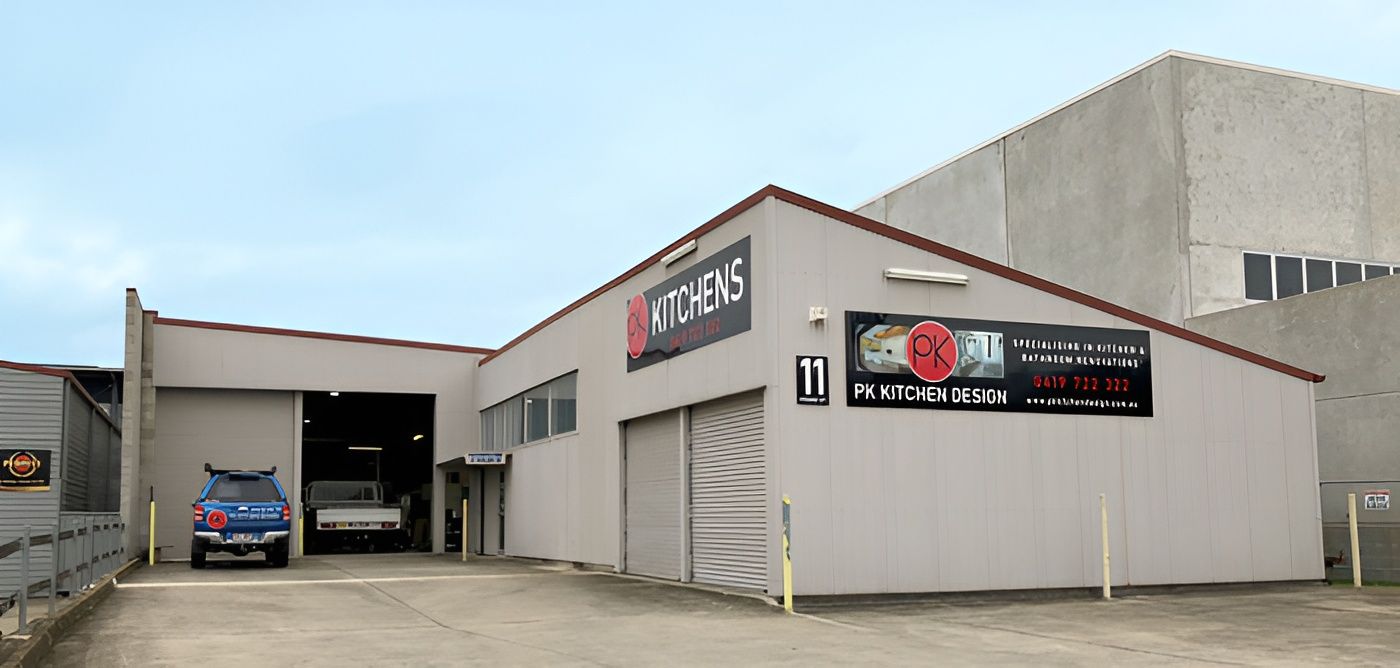 A Business Building With a Red and Black Sign — PK Kitchen Design in West Ipswich, QLD