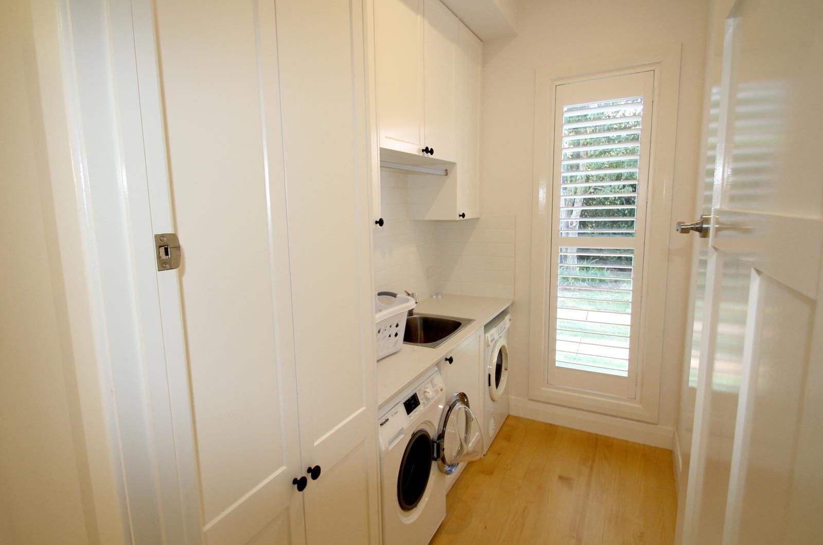 Laundry Room With White Cabinets, Washer, Dryer — PK Kitchen Design in West Ipswich, QLD