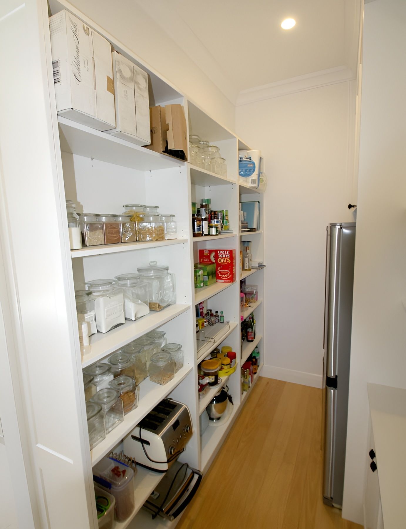 A Pantry With White Shelves Full of Jars, Containers, and Food — PK Kitchen Design in West Ipswich, QLD