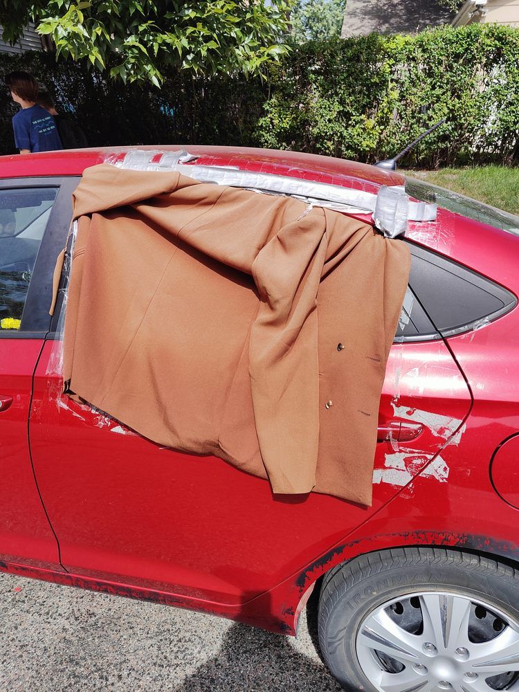A red car with a brown cloth on the door